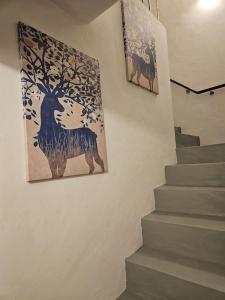 una pintura de un ciervo y un árbol en una pared en Refúgio de Arez-Alojamento Local, en Arez