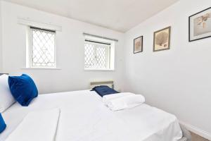 Duas camas brancas num quarto branco com duas janelas em Beautiful House by Station with Private Parking em Cambridge