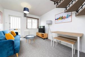 uma sala de estar com um sofá azul e uma secretária em Beautiful House by Station with Private Parking em Cambridge