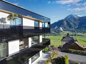 a house with a view of the mountains at Timeless Dolomites Apartments in Dobbiaco