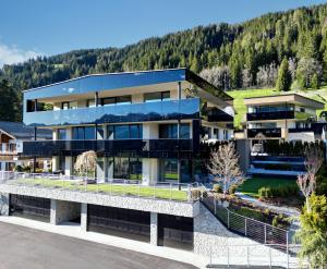 a large building with a mountain in the background at Timeless Dolomites Apartments in Dobbiaco