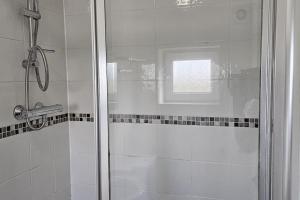 een douche met een glazen deur in de badkamer bij A well looked after 2 bedroom flat in Sheffield