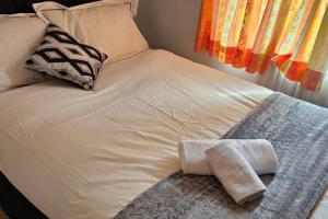 een wit bed met twee handdoeken erop bij A well looked after 2 bedroom flat in Sheffield