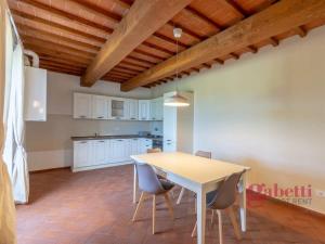 a kitchen and dining room with a table and chairs at La Macchia - I Borghi Della Selvaccia in Cennina