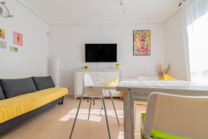 ein Wohnzimmer mit einem gelben Sofa und einem Tisch in der Unterkunft Villa Piña in Corralejo