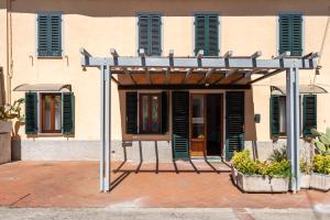 a building with a pergola in front of it at Casa dei Pini Pieve a Nievole in Pieve a Nievole