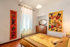 1 dormitorio con 1 cama y una pintura en la pared en Casa dei Pini Pieve a Nievole, en Pieve a Nievole