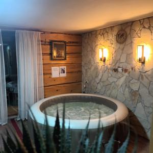 a bath tub in a room with a stone wall at PLITVICE MAGIC in Rudanovac