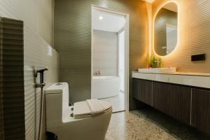 ein Badezimmer mit Toilette, Waschbecken und Spiegel in der Unterkunft La Vista Patong Hotel in Patong Beach + 37 Fotos