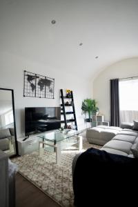 盧頓的住宿－Luxury 2 Bed Apartment in Town Centre - FREE WIFI!!，带沙发和玻璃桌的客厅