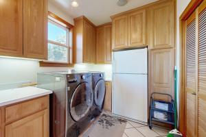 a kitchen with a refrigerator and a washer and dryer at Anchors Aweigh in Rockaway Beach +23 photos