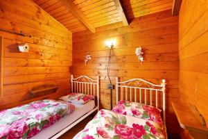 a room with two beds in a wooden cabin at Orserose Chalet 1 La Bilancia in Forno di Zoldo