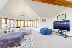 a living room with a couch and a flat screen tv at Anchors Aweigh in Rockaway Beach