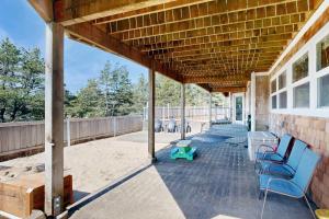 a covered porch with blue benches and a table at Anchors Aweigh in Rockaway Beach