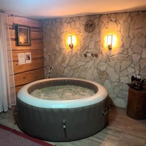 a large tub in a room with a stone wall at PLITVICE MAGIC in Rudanovac