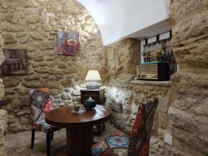 kamienny pokój z drewnianym stołem i krzesłami w obiekcie Proserpina w mieście Enna