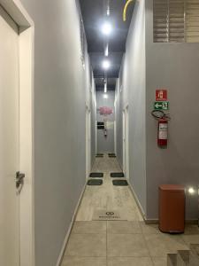 a hallway with a long corridor with white walls at 44 LOFT DUPLO · LOFT perto do São Paulo Expo e c estacionamento in Sao Paulo