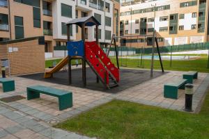 ein Spielplatz mit Rutsche und Bänken in einem Park in der Unterkunft Casadiella, apartamento con terraza y piscina, playa 3 km VUT-5630-AS in Llanes