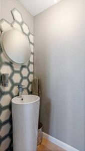 ein Badezimmer mit Waschbecken und Spiegel in der Unterkunft Ocean Drive Oasis w Hot Tub Awaits in Corpus Christi + 59 Fotos