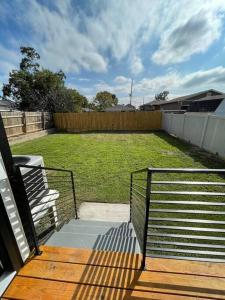 een veranda met een bank en een tuin met een hek bij Modern 3 bedrm 5 mins 2 airport free parking wi-fi in Kenner