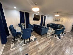 a living room with blue couches and a table at Modern 3 bedrm 5 mins 2 airport free parking wi-fi in Kenner