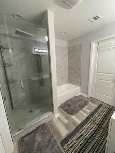 a bathroom with a shower with a glass door at Modern 3 bedrm 5 mins 2 airport free parking wi-fi in Kenner