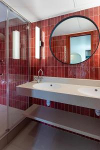 La salle de bains est pourvue de 2 lavabos et d'un miroir. dans l'établissement Hotel Sacha, à Paris