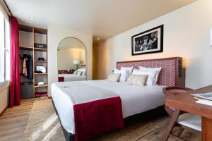 sypialnia z dużym łóżkiem, stołem i biurkiem w obiekcie Hotel Sacha w Paryżu