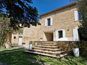 - un bâtiment en pierre avec des escaliers devant dans l'établissement Mas de la Sorgue - Rendez-vous en Provence, à Bédarrides