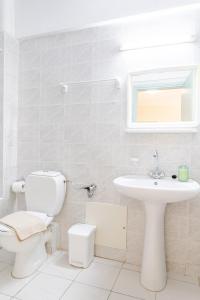biała łazienka z toaletą i umywalką w obiekcie Ostria Studios w Retimnie