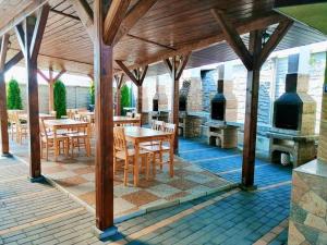 a patio with tables and chairs and an outdoor kitchen at MarLiv Complex in Tăşnad