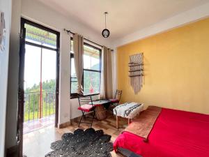 a bedroom with a bed and a desk and a window at The Hostel Stories Dharamkot - Mcleodganj in McLeod Ganj