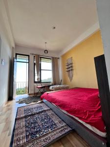 a bedroom with a red bed and a rug at Mitra Homes Dharamkot in McLeod Ganj