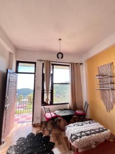 a living room with two tables and two windows at Mitra Homes Dharamkot in McLeod Ganj