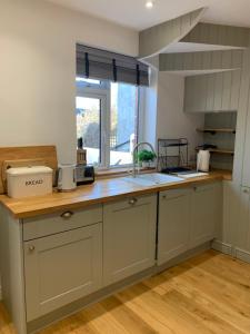 a kitchen with a counter with a sink and a window at Rose Cottage in Lustleigh