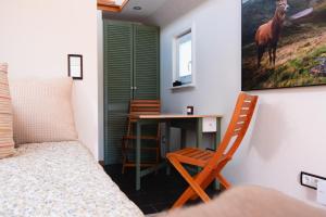 a bedroom with a bed and a desk with a horse painting on the wall at Ilsehof Tiny-House Mimi 