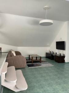 - un salon avec un canapé et une télévision dans l'établissement „Sėlių Studio“ Apartamentai, à Utena