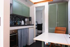 a kitchen with green cabinets and a white counter top at Ilsehof Tiny-House Mimi 