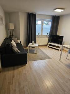 ein Wohnzimmer mit einem Sofa und einem Flachbild-TV in der Unterkunft Ferienappartement Kassel-Waldau in Kassel