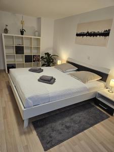 a bedroom with a large white bed with two towels on it at Ferienappartement Kassel-Waldau in Kassel