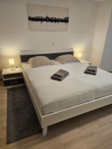 um quarto com uma grande cama branca com duas toalhas em Ferienappartement Kassel-Waldau em Kassel