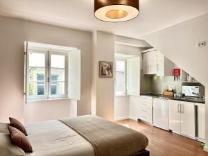 a bedroom with a bed and a kitchen at Casa da Moeda by Escapadinha Portuguesa in Coimbra