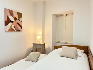 1 dormitorio con 1 cama y una pintura en la pared en Casa da Moeda by Escapadinha Portuguesa en Coimbra