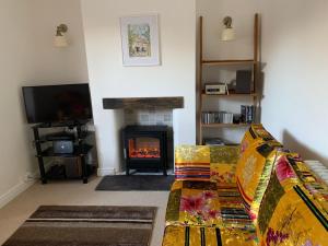 a living room with a couch and a fireplace at Rose Cottage in Lustleigh