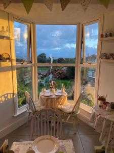 a table and chairs in a room with a large window at Green Apple Bed and Breakfast in St Ives