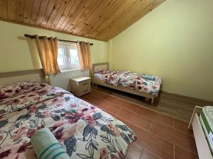 1 dormitorio con 2 camas y ventana en Guest House Artjon en Fierzë