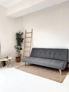 un sofá sentado en una sala de estar con una escalera en Studio with wifi at Bruxelles, en Bruselas