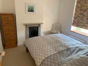 a bedroom with a bed and a fireplace at Rose Cottage in Lustleigh