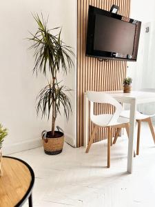 una sala da pranzo con tavolo bianco e pianta in vaso di Studio with wifi at Bruxelles a Bruxelles