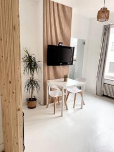 a white table and chairs in a room with a tv at Studio with wifi at Bruxelles in Brussels